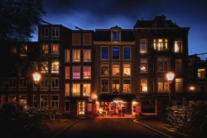 Cosy coffeehouse at Prinsengracht, illuminated at blue hour, old lanterns on the brindge, Amsterdam, Netherlands