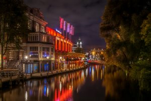 Brightly illuminated night scene at Rozengracht with the Casino, red, water, reflections, Amsterdam, Netherlands